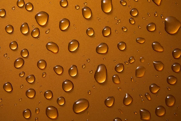 Abstract water drops on gold bronze background, macro, Bubbles close up, Cosmetic moisturizing liquid drops, Flat lay pattern.