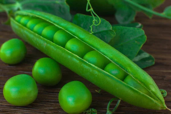 オークボード上の緑のエンドウ豆のポッドは — ストック写真