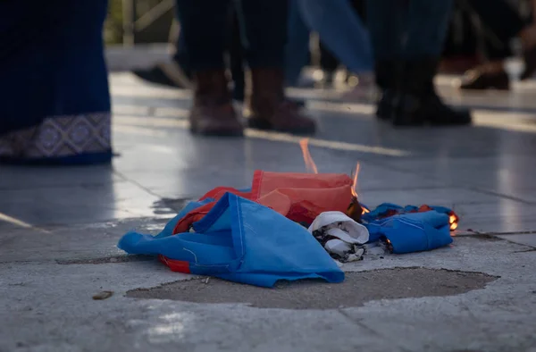 SYNTAGMA SQUARE, ATHENS, GREECE - April 3rd, 2022: Torn to pieces and set on fire Russian flag lying on the sidewalk at protest against the WAR in UKRAINE. — Stockfoto