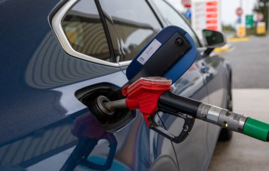 Mavi araba benzin istasyonunda yakıt ikmali yapıyor..