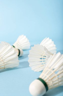 parlak mavi arka planda oynadıktan sonra badminton tüyleri. dikey.