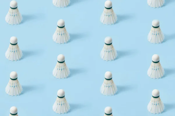 Parlak mavi arka planda baş aşağı duran güzel profesyonel badminton tüyleri.