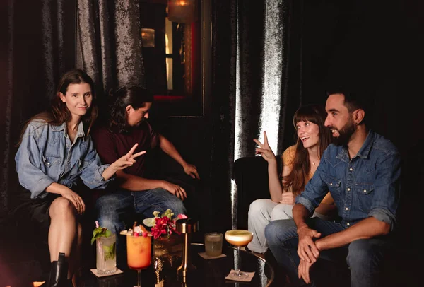 İki kız ve iki erkek bir gece kulübünde kokteyllerle takılıyorlar.