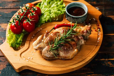 Çeri domatesli ve salatalı ahşap bir tahtada domuz bifteği. Kırsal yiyecekler