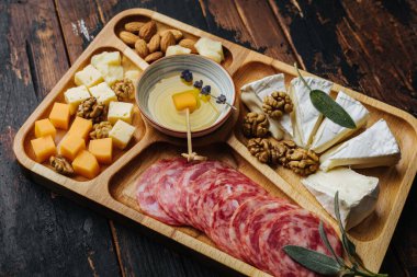 Şarap aperatifleri. Tahtada çeşitli peynirler..