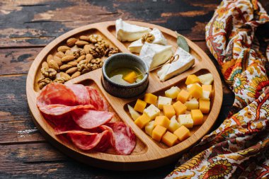 Şarap aperatifleri. Tahtada çeşitli peynirler..