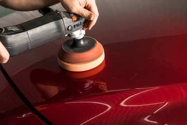 Polishing the body of a red car — Stok fotoğraf