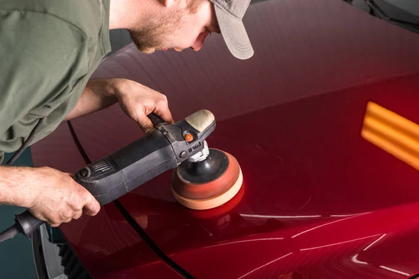 Polishing the body of a red car — Stockfoto