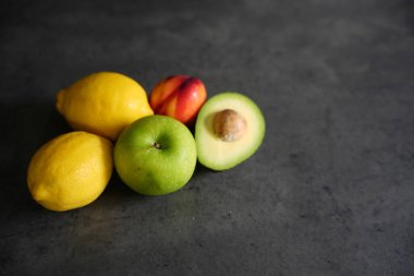 Masada taze taze organik meyve, limon, elma ve avokado karışımı.