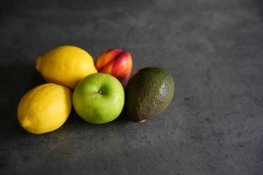 Masada taze taze organik meyve, limon, elma ve avokado karışımı.