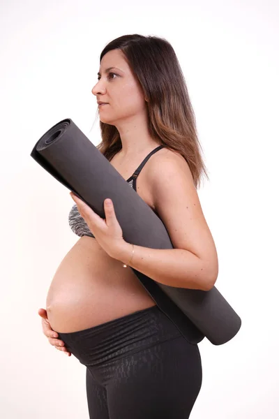 40成熟した妊娠中の大人で運動服とともにヨガマットワークアウトで自宅 — ストック写真