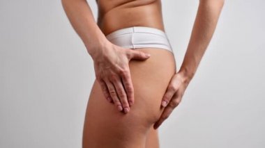 Kadın selülit gösteriyor, kalçasındaki yağ seviyesini kontrol ediyor.