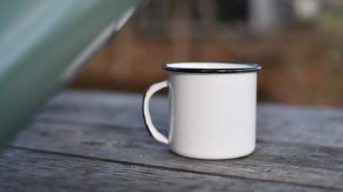 Sonbahar yürüyüşü sırasında termostan sıcak çay dolduran kadın..