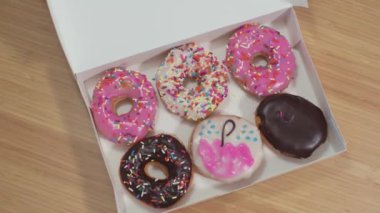 Masanın üstündeki kutudan çörekleri alan insanlar gibi. Ofisteki kutudan çörek alan bir sürü el.