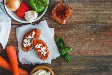 Domates sosuyla kaplı kepekli ekmek ve eski ahşap masa üzerinde beyaz peynir. Ev yapımı organik sebze yemeği..