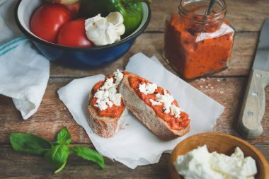 Domates sosuyla kaplı kepekli ekmek ve eski ahşap masa üzerinde beyaz peynir. Ev yapımı organik sebze yemeği..
