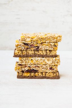 Bir yığın ev yapımı tahıl gevreği, fındık, tohum, siyah çikolata, bal ve böğürtlen ile ahşap bir arka planda