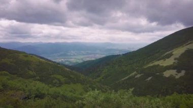 Yazın başlarında geniş vadiler ve yeşil çayırlar ile Slovakya 'nın kuzeyindeki High Tatras eteklerindeki doğal manzara.