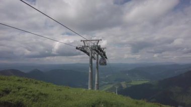 Yaz başında Slovakya 'nın kuzeyindeki High Tatras eteklerinde geniş vadiler ve yeşil çayırlar bulunan kablo arabalar.