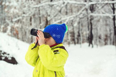 Çocuk tek göz olmak istiyor. Aile kış tatili. Doğada kış eğlencesi. Karlı ormandaki sevimli çocuk kâşifi. Aile tatili, karlı bir gün ve mutlu bir çocukluk. Mutlu çocuk kış ormanlarında yürüyor.