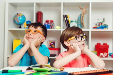 Çocuklar yeni okul projesini düşünüyor. Okul çocukları birlikte egzersiz yapıyor. Okul konseptine geri dönelim. Sınıftaki masada oturan sevimli öğrenciler var. Eğitim, ilkokul.