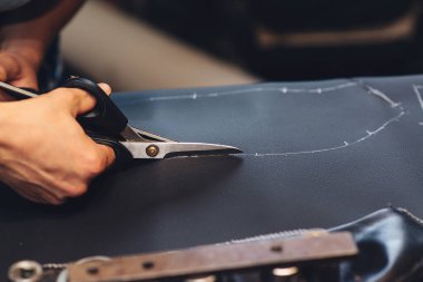 El yapımı deri ustası. İşçi, deri ürün dikiyor. Deri işçi atölyesi. Araba koltuğu örtüsü dikiyorum. Adam el işi aletini tutuyor ve çalışıyor, kapat. El yapımı şeyler yapmak..