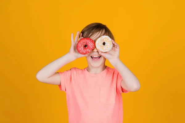 Roztomilý Vtipálek Držící Koblihy Očích Šťastné Dítě Hrálo Koblihami Žlutém — Stock fotografie