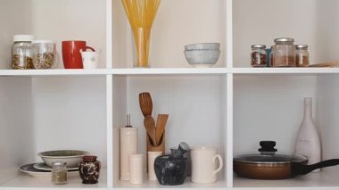 Mutfak gereçleri ve sofra takımı beyaz raflarda. İyi organize edilmiş mutfak konsepti. Modern iç mekan. Dolabı temiz tabaklarla açın..