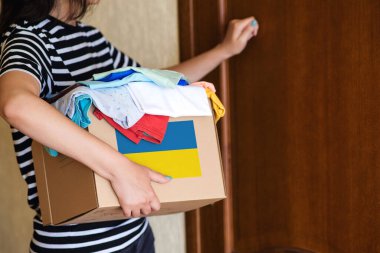 Ukraynalı mülteciler için insani yardım kutusuyla gönüllü cyrrying kutusu. Sadakalar, yoksullara ve düşkünlere verilir. Ukrayna 'da kal. Savaştan muzdarip Ukraynalı mülteciler için bağış giysileriyle dolu bir kutu..