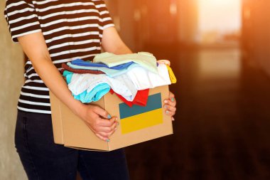 Ukraynalı mülteciler için insani yardım kutusuyla gönüllü cyrrying kutusu. Sadakalar, yoksullara ve düşkünlere verilir. Ukrayna 'da kal. Savaştan muzdarip Ukraynalı mülteciler için bağış giysileriyle dolu bir kutu..