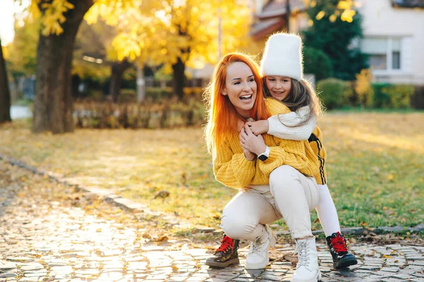 快乐的妈妈和女儿在秋天的公园里散步 妇女和儿童女儿在户外玩耍 妈妈和女孩在外面笑秋天的时尚 快乐的家庭在一起开心 — 图库照片