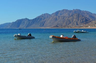 Anchored powerboats at the sea bay in the background of distant mountains