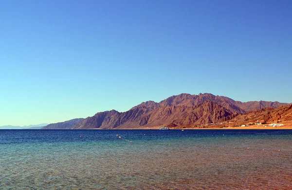 Uzak dağların arkasındaki Dahab gölünün manzarası. Sina Yarımadası, Mısır.