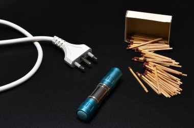 Kibritleri yakın çekim, güç kablosu ve siyah arka planda el feneri. Elektrik tedarik sorunu kavramı. karartma