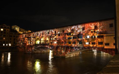 Floransa - Aralık 2020: Arno üzerindeki ünlü Ponte Vecchio, Noel tatili sırasında Floransa Işık Festivali vesilesiyle aydınlandı. İtalya.