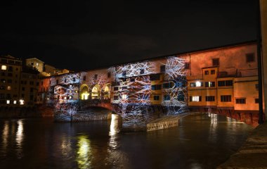 Floransa - Aralık 2020: Arno üzerindeki ünlü Ponte Vecchio, Noel tatili sırasında Floransa Işık Festivali vesilesiyle aydınlandı. İtalya.
