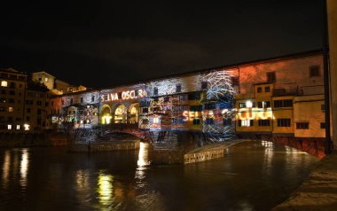 Floransa - Aralık 2020: Arno üzerindeki ünlü Ponte Vecchio, Noel tatili sırasında Floransa Işık Festivali vesilesiyle aydınlandı. İtalya.