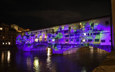 Floransa - Aralık 2020: Arno üzerindeki ünlü Ponte Vecchio, Noel tatili sırasında Floransa Işık Festivali vesilesiyle aydınlandı. İtalya.