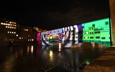 Floransa - Aralık 2020: Arno üzerindeki ünlü Ponte Vecchio, Noel tatili sırasında Floransa Işık Festivali vesilesiyle aydınlandı. İtalya.