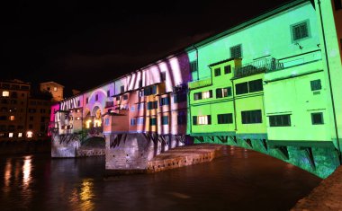 Floransa - Aralık 2020: Arno üzerindeki ünlü Ponte Vecchio, Noel tatili sırasında Floransa Işık Festivali vesilesiyle aydınlandı. İtalya.