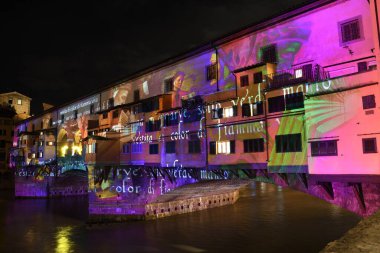 Floransa - Aralık 2020: Arno üzerindeki ünlü Ponte Vecchio, Noel tatili sırasında Floransa Işık Festivali vesilesiyle aydınlandı. İtalya.