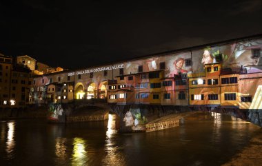 Floransa - Aralık 2020: Arno üzerindeki ünlü Ponte Vecchio, Noel tatili sırasında Floransa Işık Festivali vesilesiyle aydınlandı. İtalya.