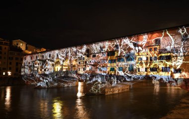 Floransa - Aralık 2020: Arno üzerindeki ünlü Ponte Vecchio, Noel tatili sırasında Floransa Işık Festivali vesilesiyle aydınlandı. İtalya.