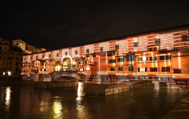 Floransa - Aralık 2020: Arno üzerindeki ünlü Ponte Vecchio, Noel tatili sırasında Floransa Işık Festivali vesilesiyle aydınlandı. İtalya.