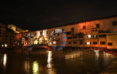 Floransa - Aralık 2020: Arno üzerindeki ünlü Ponte Vecchio, Noel tatili sırasında Floransa Işık Festivali vesilesiyle aydınlandı. İtalya.