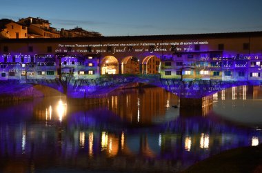 Floransa - Aralık 2020: Arno üzerindeki ünlü Ponte Vecchio, Noel tatili sırasında Floransa Işık Festivali vesilesiyle aydınlandı. İtalya.