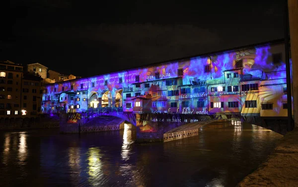 Floransa - Aralık 2020: Arno üzerindeki ünlü Ponte Vecchio, Noel tatili sırasında Floransa Işık Festivali vesilesiyle aydınlandı. İtalya.