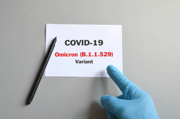 Lékařská Ruka Modrou Rukavicí Bílou Kartou Textem Covid Omicron Variant — Stock fotografie