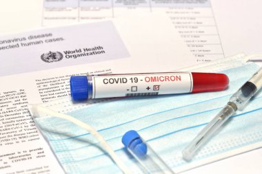 Florence, İtalya Aralık 2021: Covid-19 Omicron Variant virüsünün tespiti için alınan kan tüpü koruma maskesi ve kağıt belgeler konusunda olumlu sonuçlar verdi. Omicron Covid-19 'un yeni varyasyonundan koruma kavramı