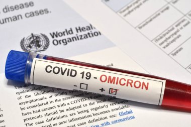 Florence, İtalya Aralık 2021: Covid-19 Omicron Variant virüsünün tespiti için alınan kan tüpü koruma maskesi ve kağıt belgeler konusunda olumlu sonuçlar verdi. Omicron Covid-19 'un yeni varyasyonundan koruma kavramı